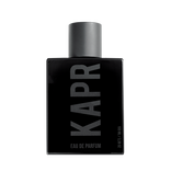 Mannelijk model met een stoere uitstraling gebruikt KAPR product.|KAPR exclusive Geur 50ml - Belangrijkste Geurkenmerken|KAPR Luxe Geur 2ml flesje met de tekst 'Eau de Essence'.|KAPR Luxe Parfum 50ml Fles en Doos - Eau de Parfum