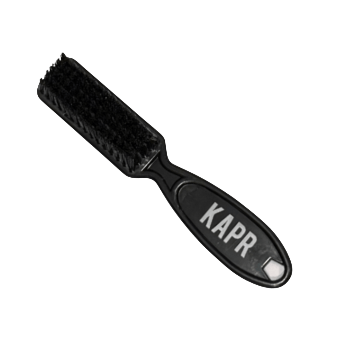 KAPR Fade borstel mini – compacte zwarte borstel met wit logo op lichte achtergrond.