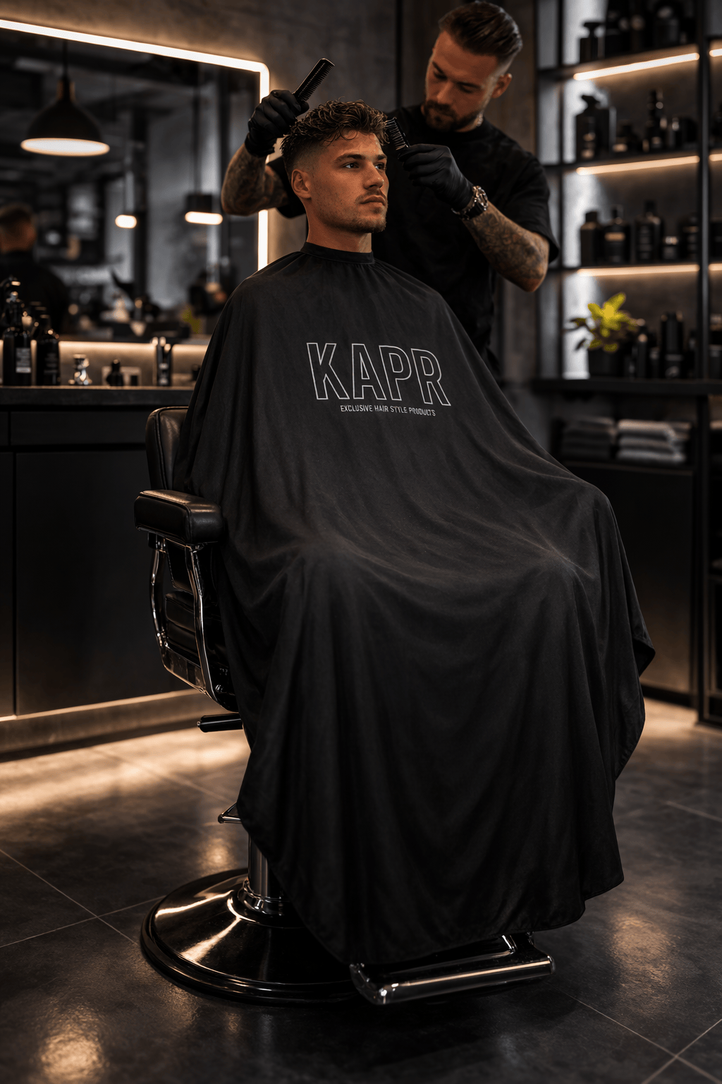 KAPR Kapmantel – zwarte barber cape gedragen in de kapsalon.