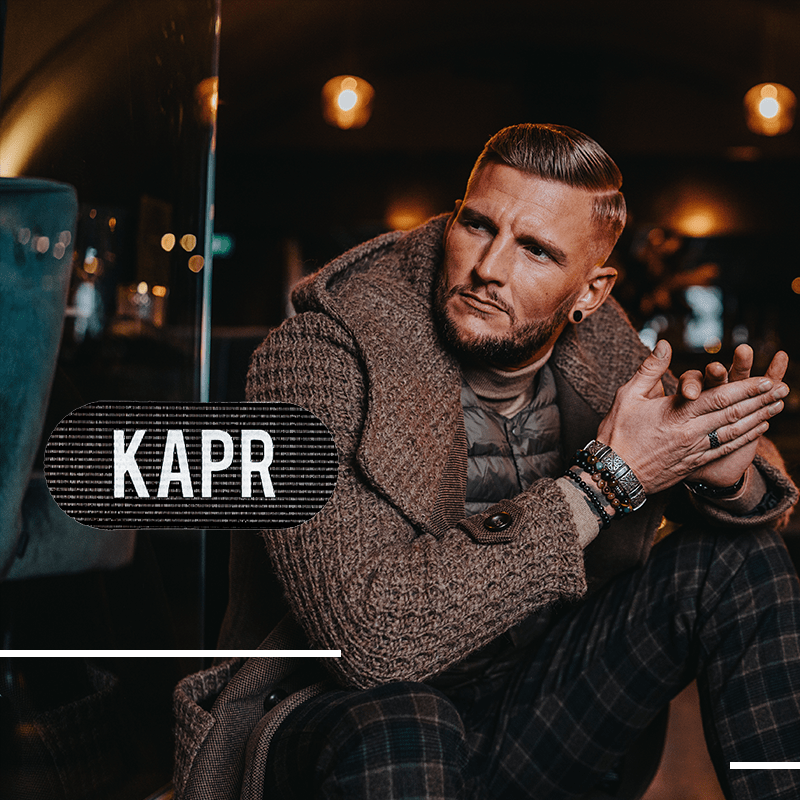 Man met baard gebruikt KAPR Grippers – professionele haargrip in barbershopomgeving.