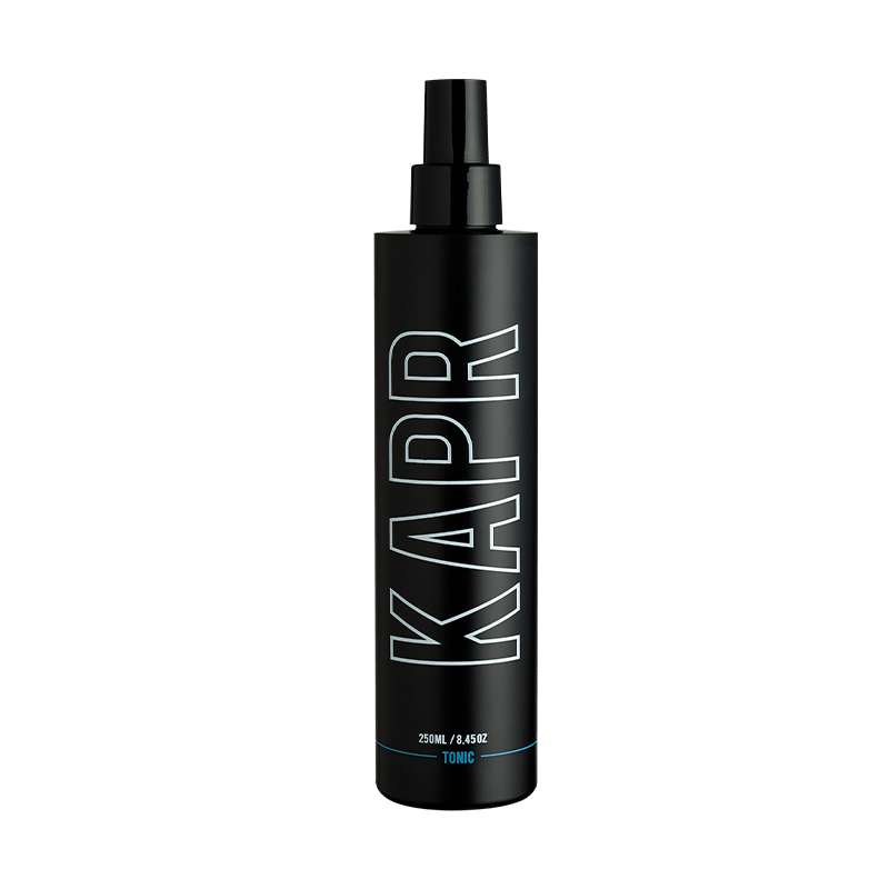 KAPR Tonic – zwarte fles met wit logo op grijze achtergrond, barbershop styling tonic.