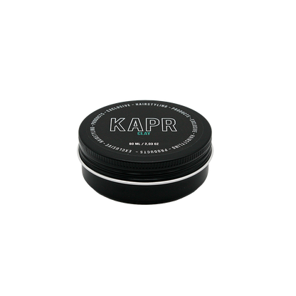 model met een strakke en matte look.|KAPR haarklei- Luxe zwarte kleiverpakking tegen een stijlvolle donkere achtergrond.||KAPR Clay 60ml met eigenschappen zoals extreme hold en verfrissende geur.