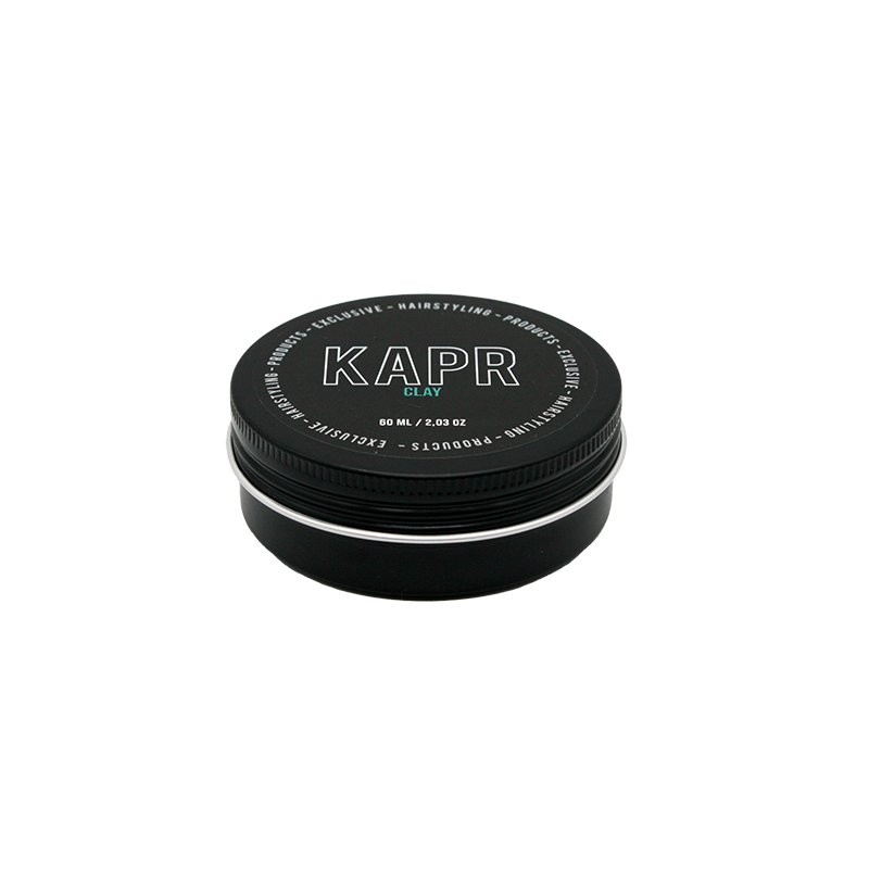 model met een strakke en matte look.|KAPR haarklei- Luxe zwarte kleiverpakking tegen een stijlvolle donkere achtergrond.||KAPR Clay 60ml met eigenschappen zoals extreme hold en verfrissende geur.