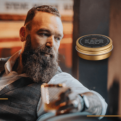 Man met baard gebruikt KAPR Beard Balm – verzorgende balsem voor een zachte, volle baard.