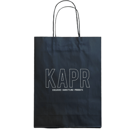 KAPR tas – zwarte papieren tas met wit logo op witte achtergrond, stijlvolle barbershop verpakking.