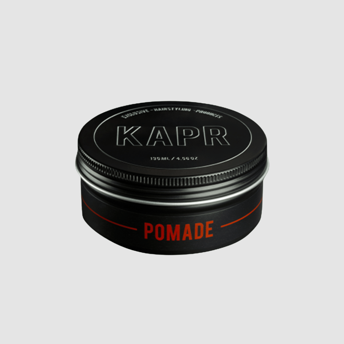 KAPR Pomade – productfoto op grijze achtergrond, elegante zwarte verpakking.