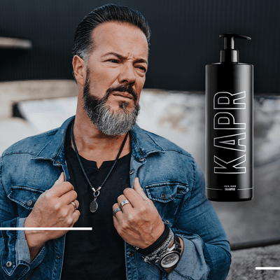 KAPR Shampoo – stijlvolle fles naast man met moderne look.