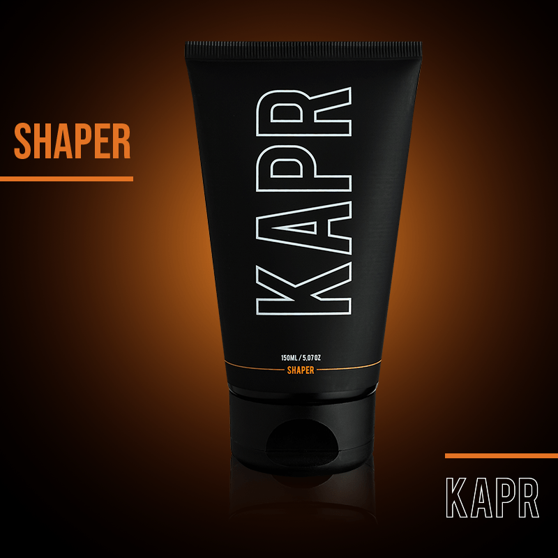 KAPR Shaper – zwarte tube met wit logo op oranje achtergrond, professionele hairstyling paste.