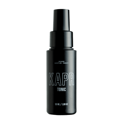 KAPR Tonic – zwarte fles met wit logo op transparante achtergrond, professionele haarverzorging.